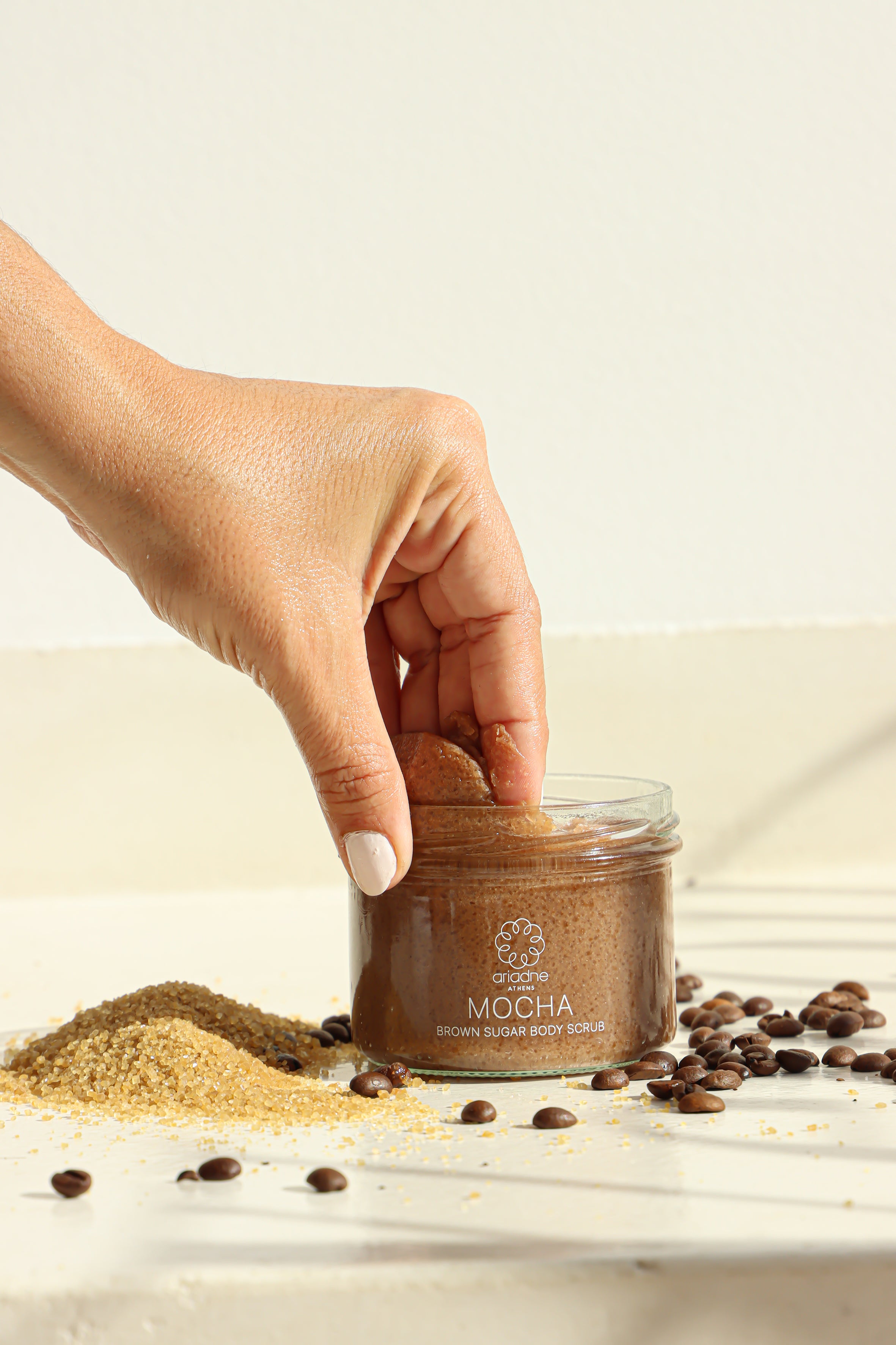 A woman uses the Mocha Brown Sugar Body Scrub.