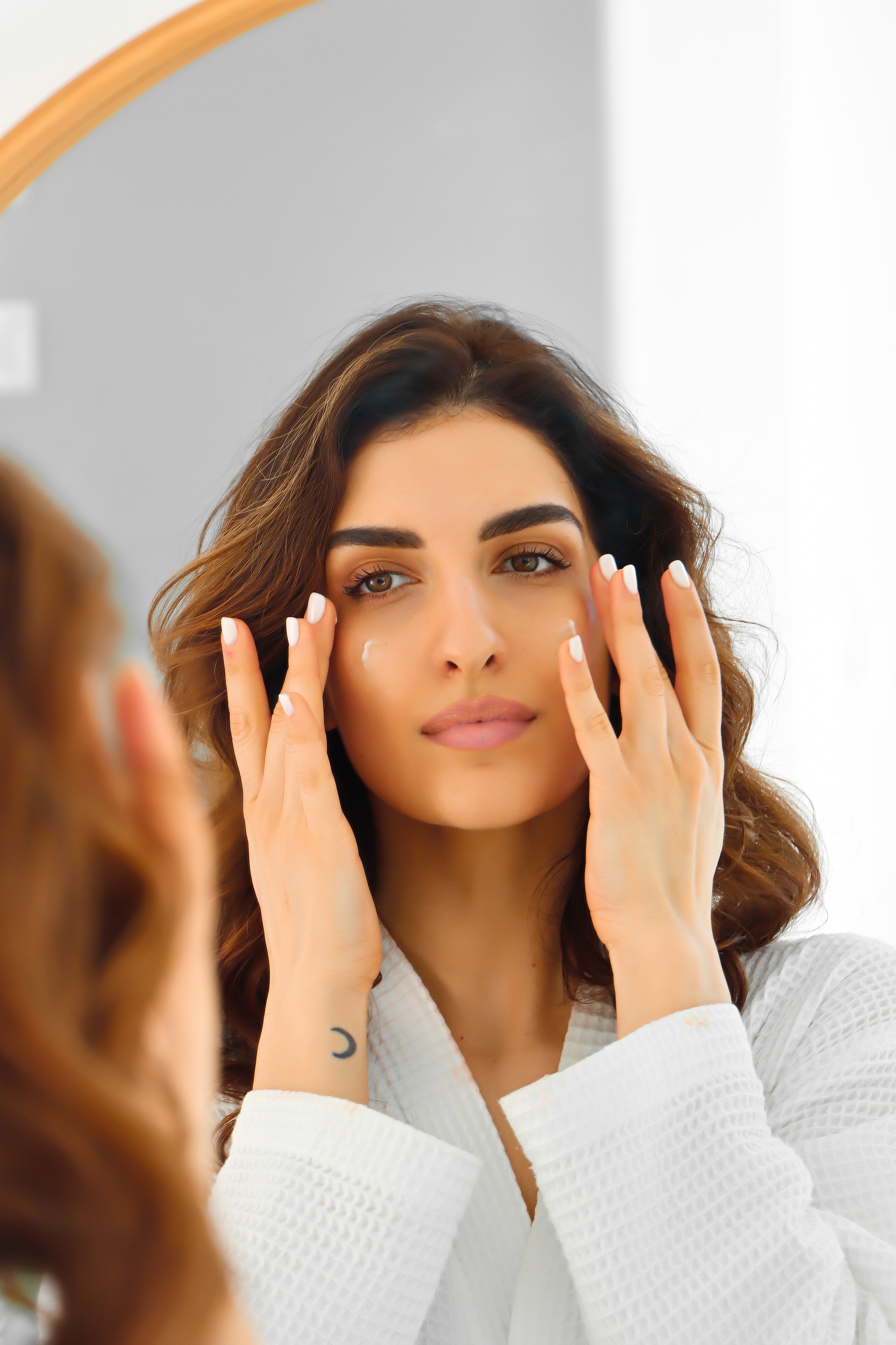 A woman applying the Hydro Elasticity Shield face cream.