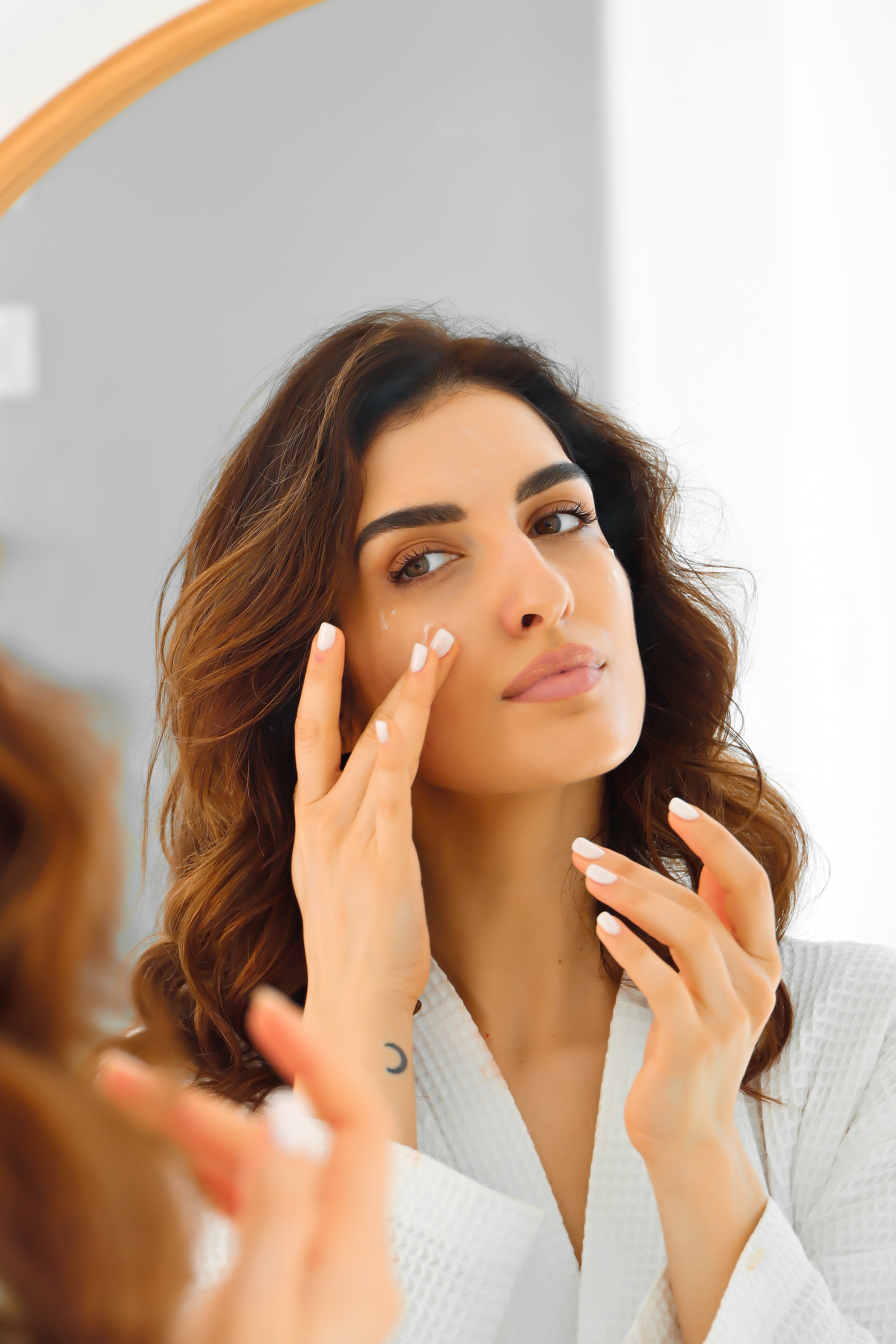 A woman applying the Hydro-Elasticity Shield face cream.