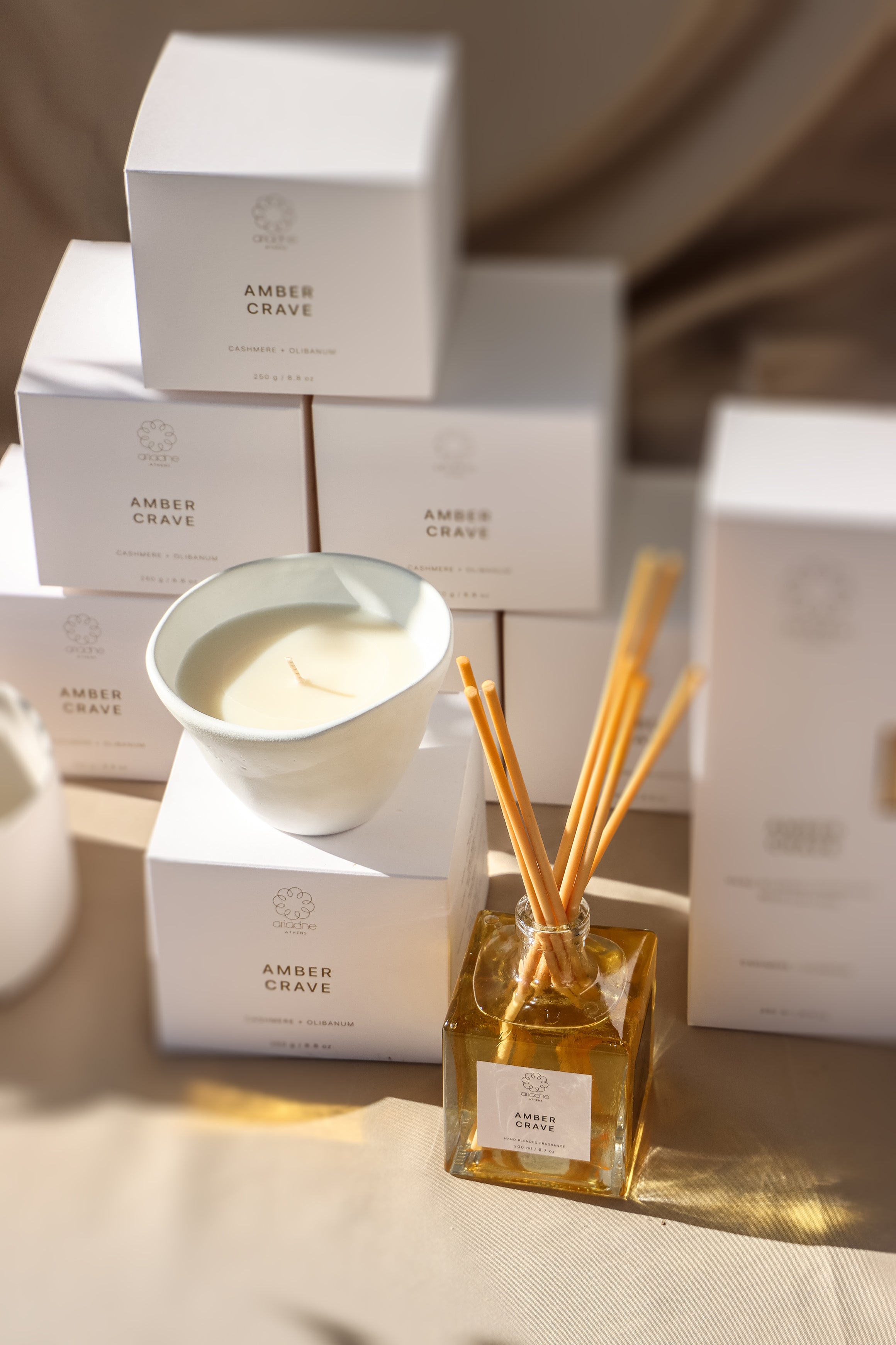 The amber crave candle with the packaging and the diffuser.